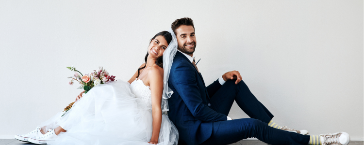 A bride and groom smile at each other while guests cheer